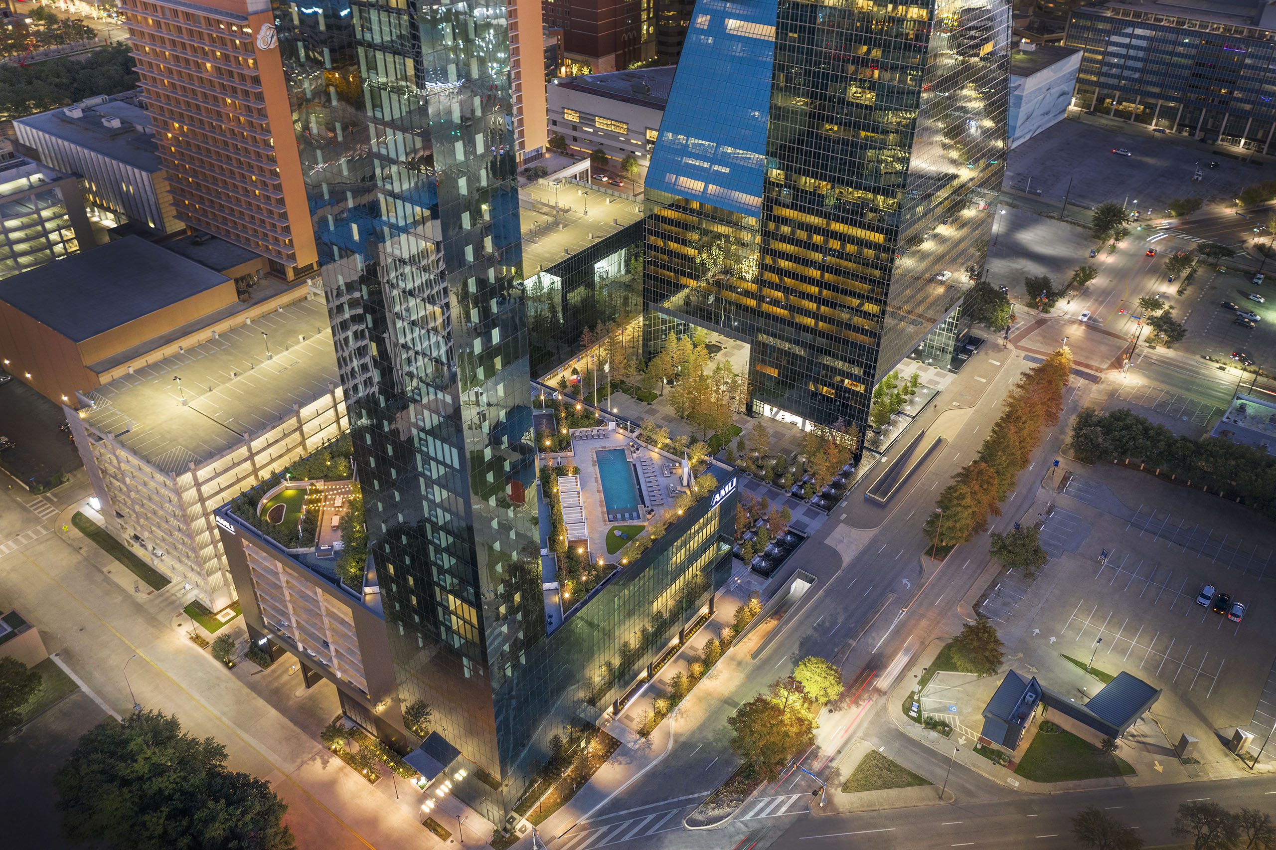 Night aerial view of AMLI Fountain Place apartment building with view of rooftops and Fountain Place office building