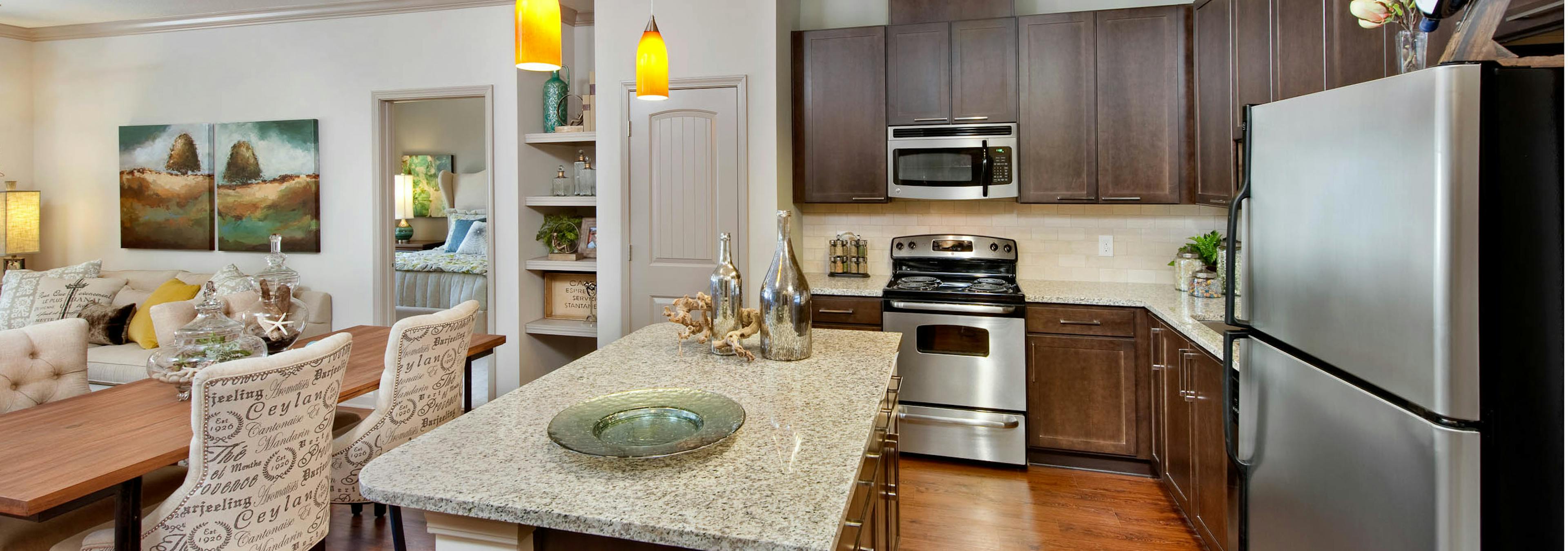 AMLI North Point kitchen with dark cabinets and granite countertops with a white backsplash and a spacious island