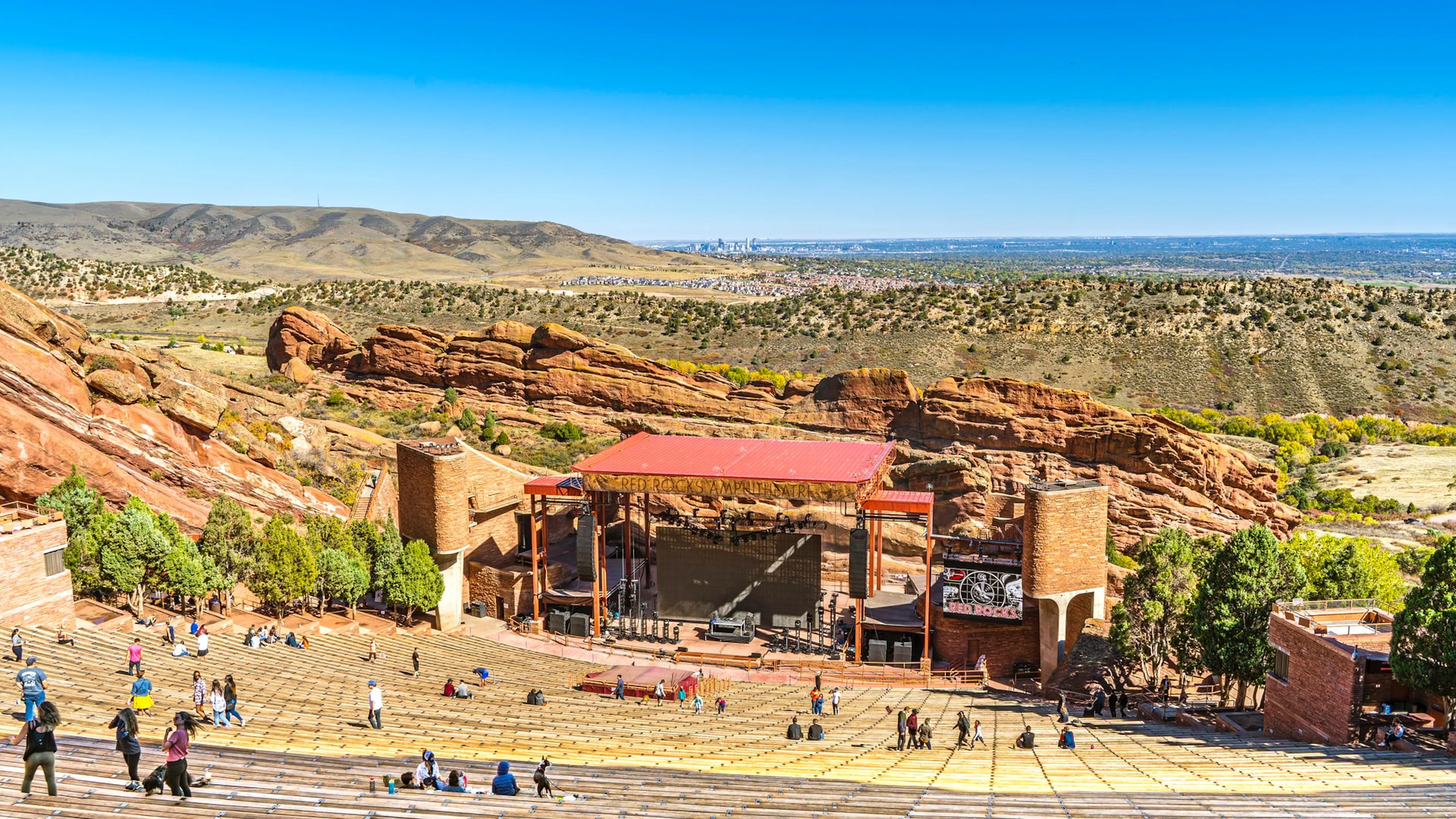 Red Rocks Park Amphitheatre with a few people in the stands on a clear sunny day