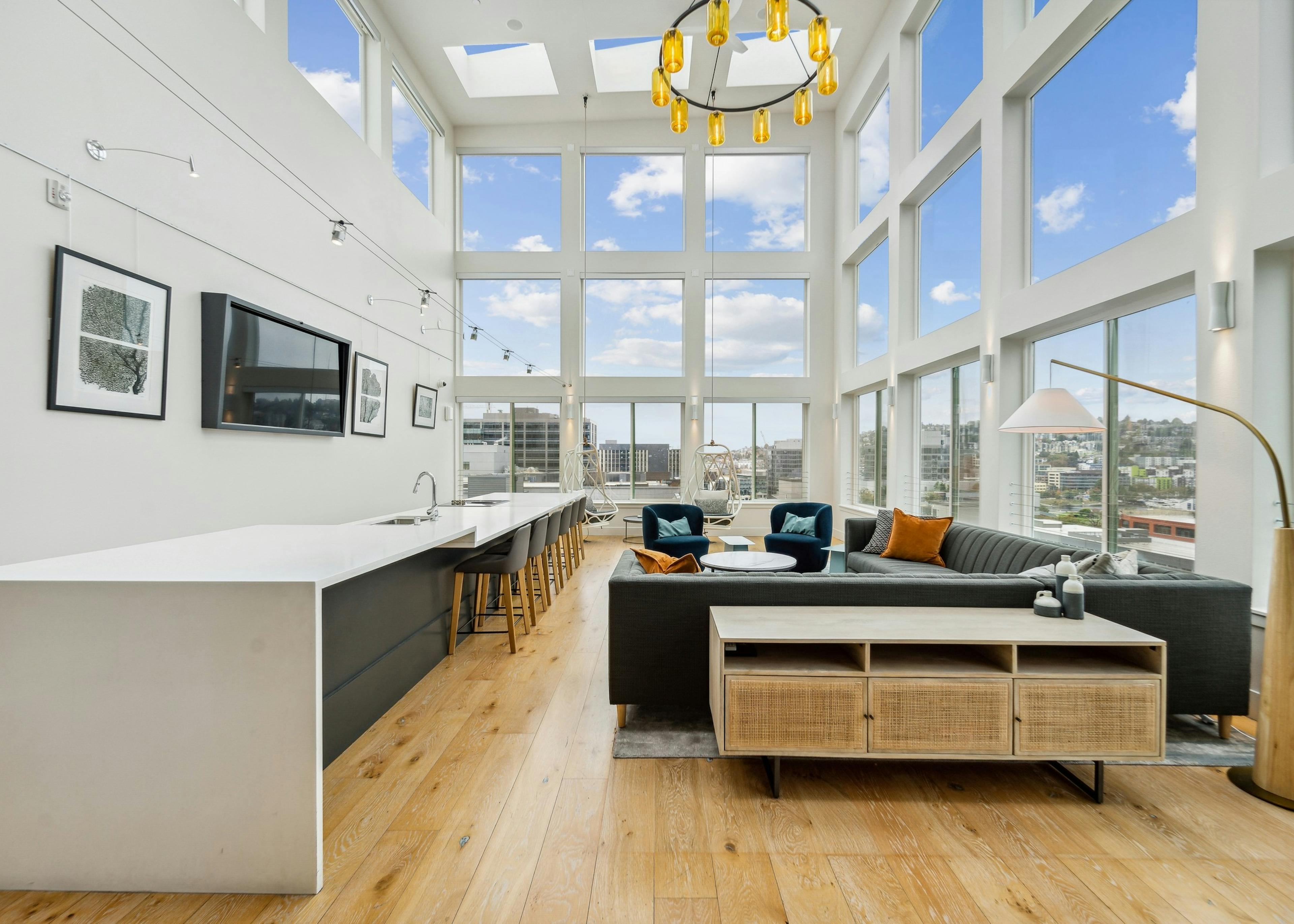 Solarium at AMLI South Lake Union with high ceilings and huge windows with scenic views and seating areas and a long island