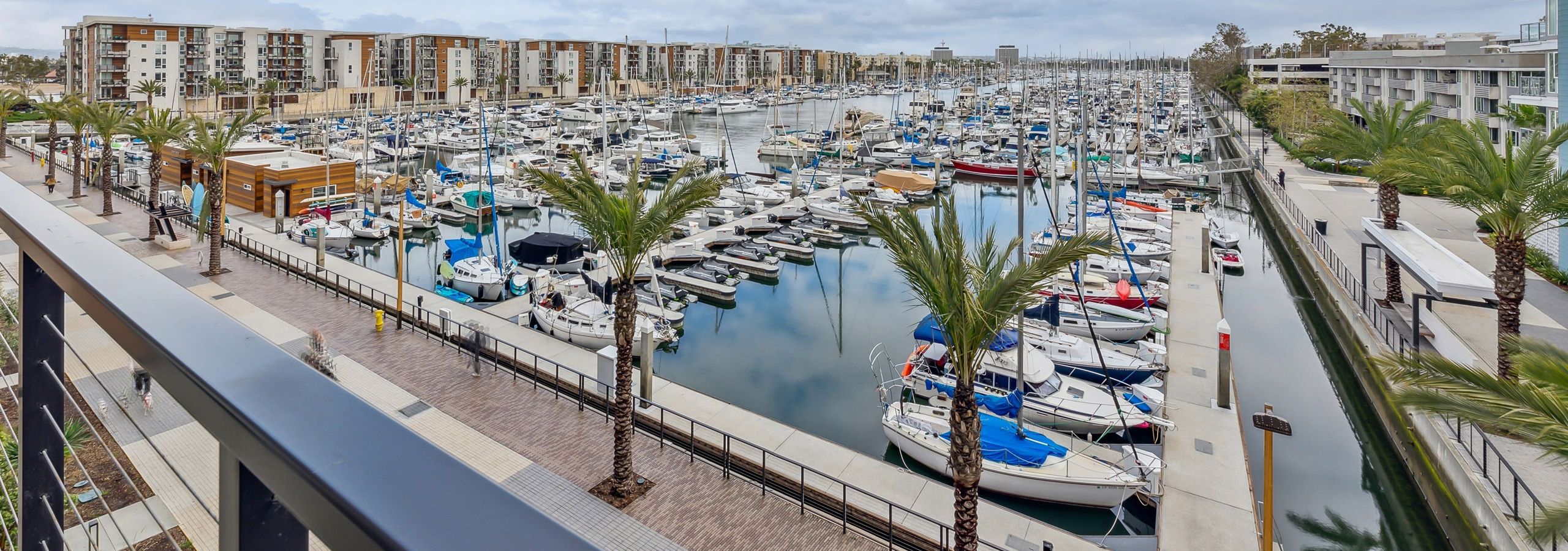View from an AMLI Marina Del Rey apartment balcony overlooking marina filled with hundreds of boats and palm trees