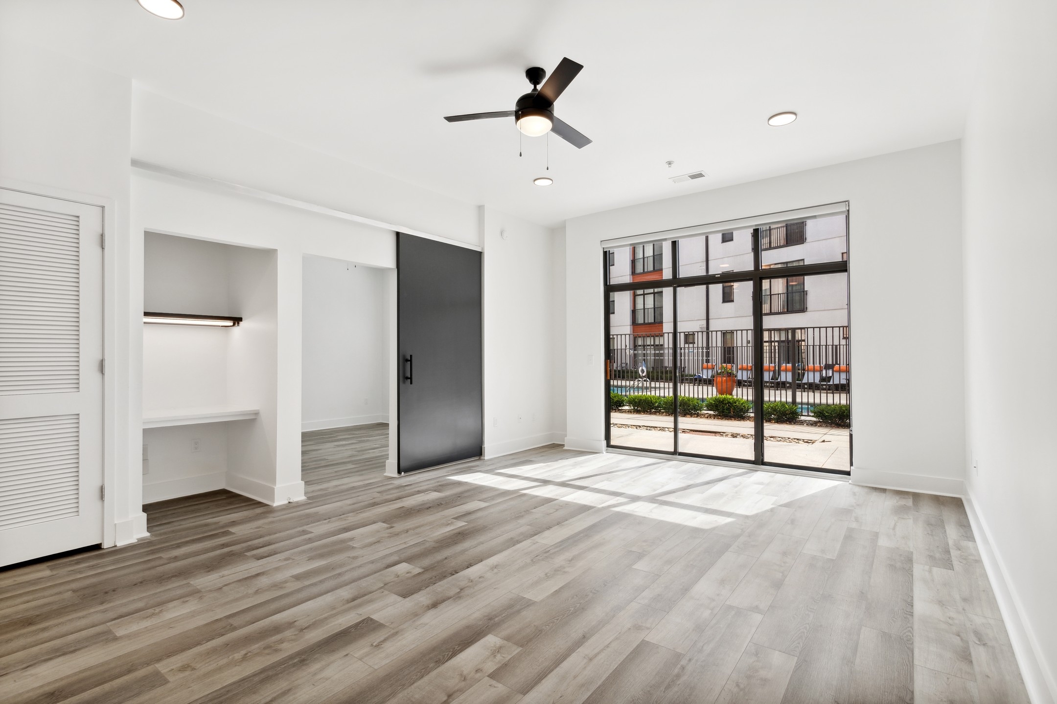 AMLI Old 4th Ward living room with gray wood flooring and office nook and bedroom sliding door and glass patio doors