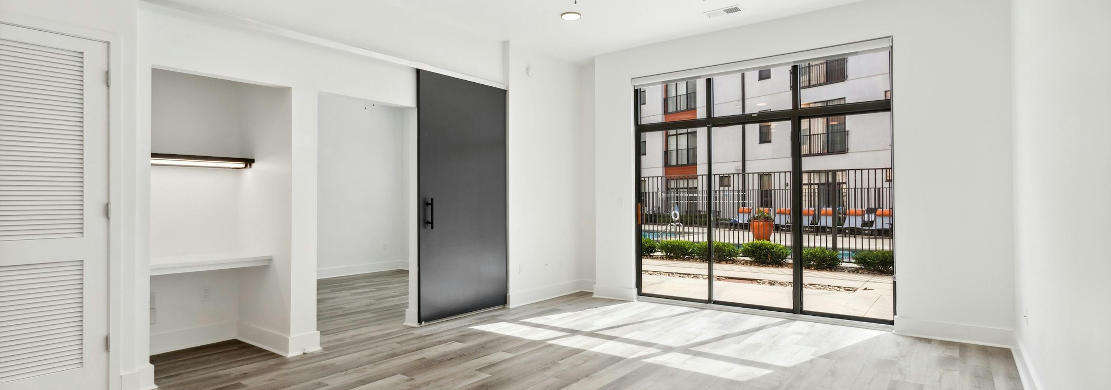 AMLI Old 4th Ward living room with gray wood flooring and office nook and bedroom sliding door and glass patio doors