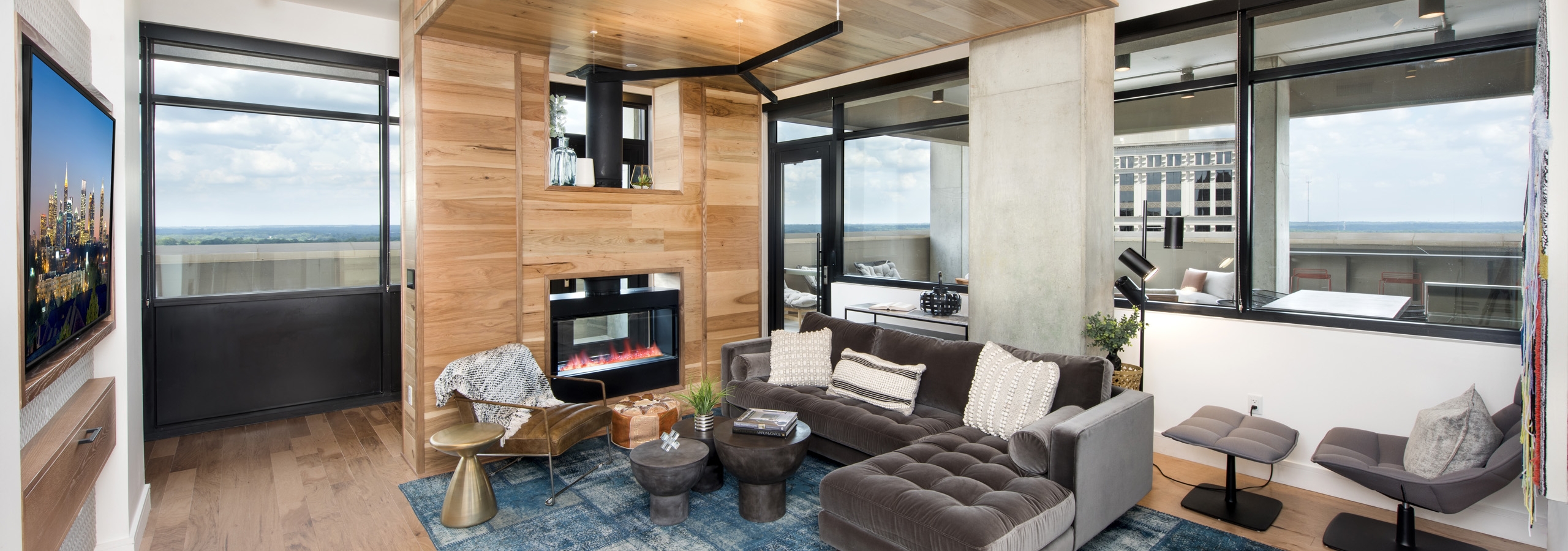 Private room within AMLI Lenox clubhouse seating area and fireplace set in wood wall with floating ceiling and a television