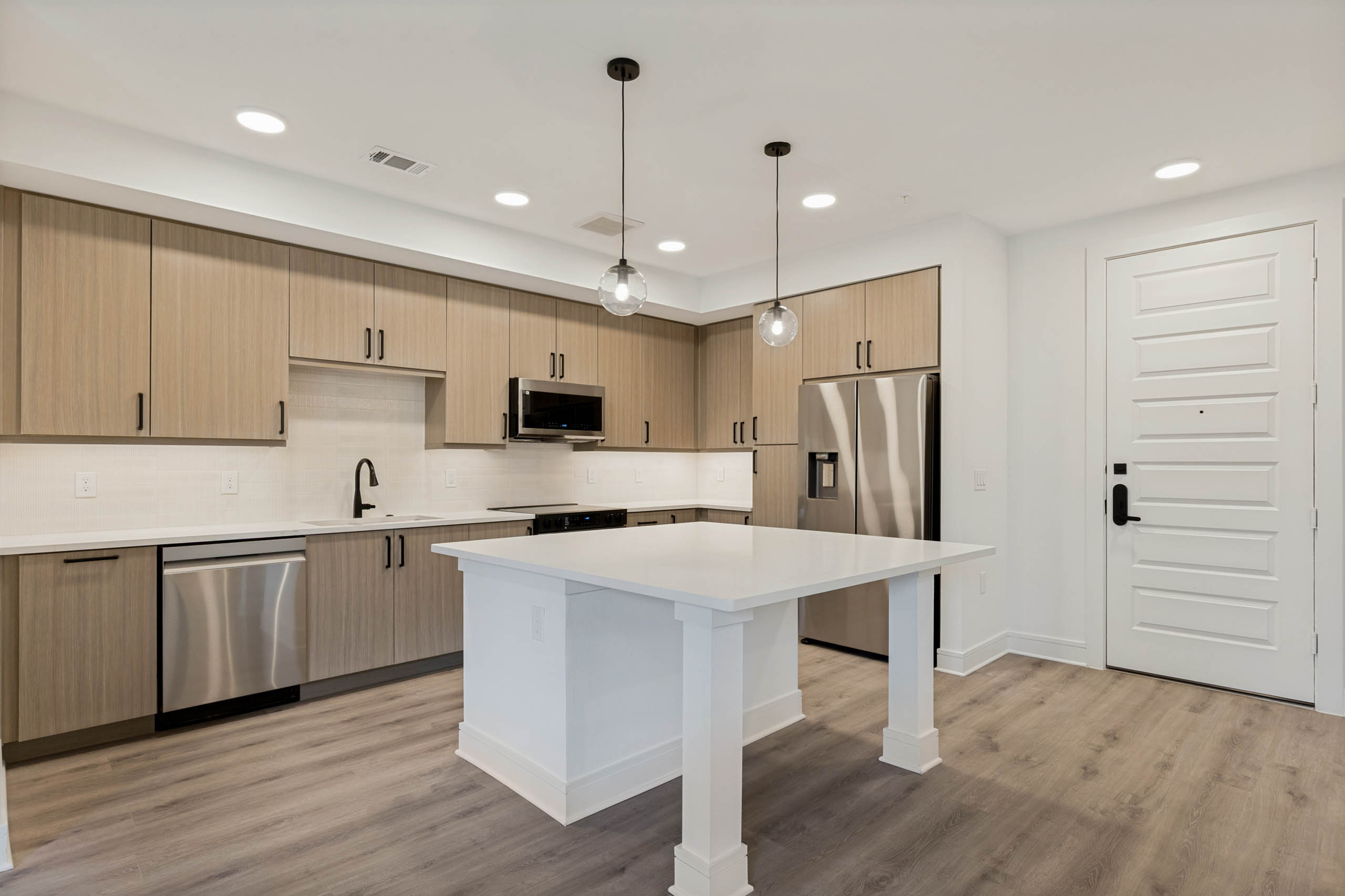 Beautiful kitchens with stainless steel appliances, wood-style cabinetry, pendant lighting, and wood flooring