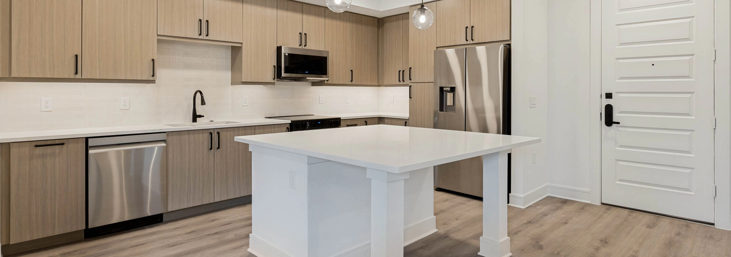 Beautiful kitchens with stainless steel appliances, wood-style cabinetry, pendant lighting, and wood flooring