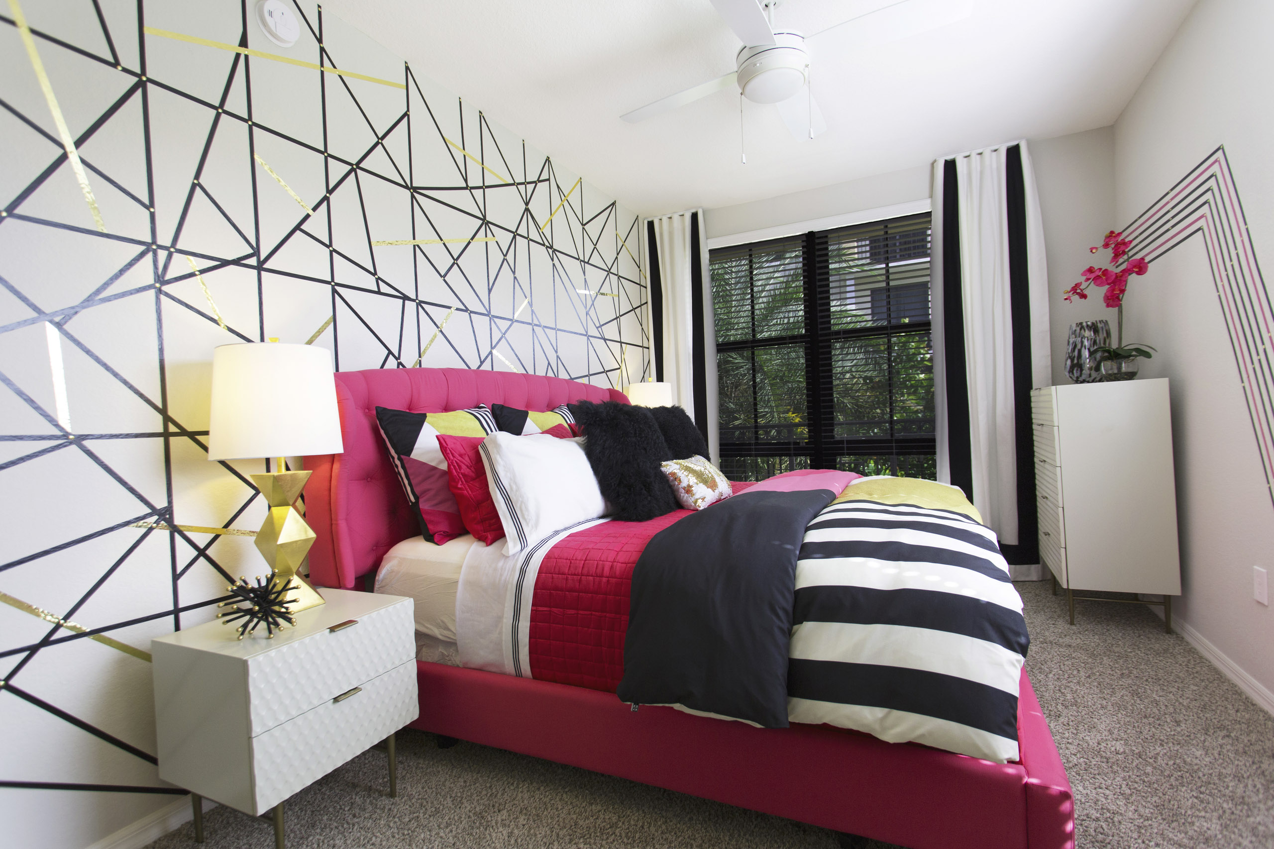 AMLI Dadeland bedroom with pink bed and black and white striped bedding.