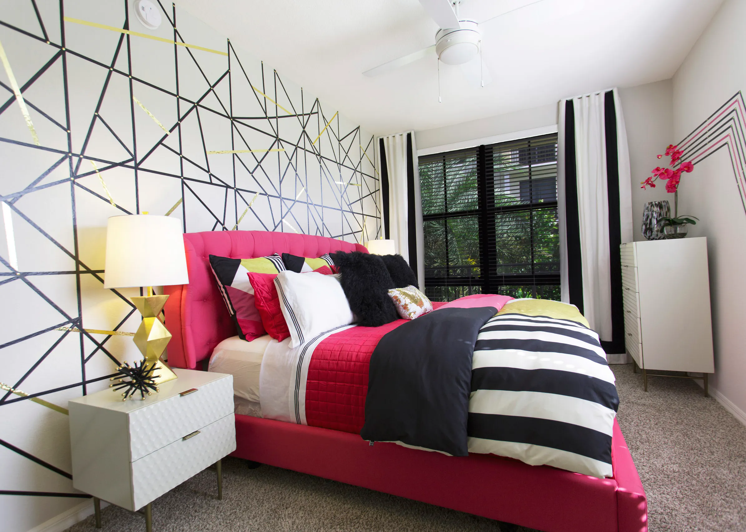 AMLI Dadeland bedroom with pink bed and black and white striped bedding.