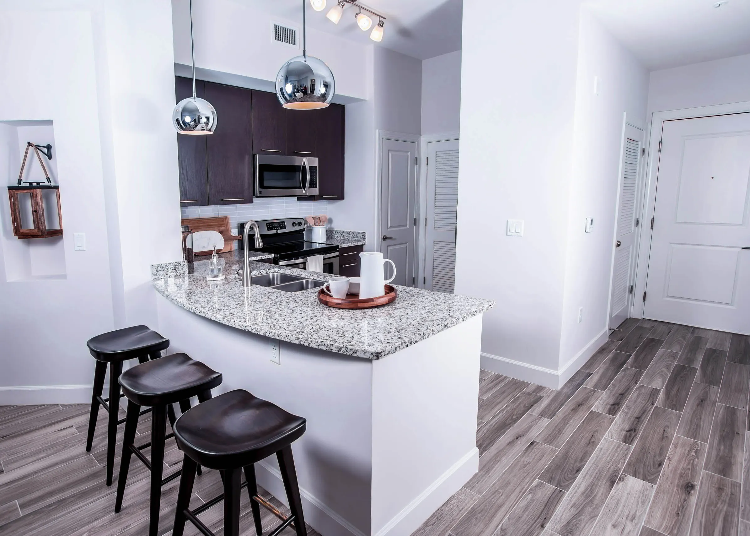 AMLI Joya Kitchen with black barstoools and granite countertops.