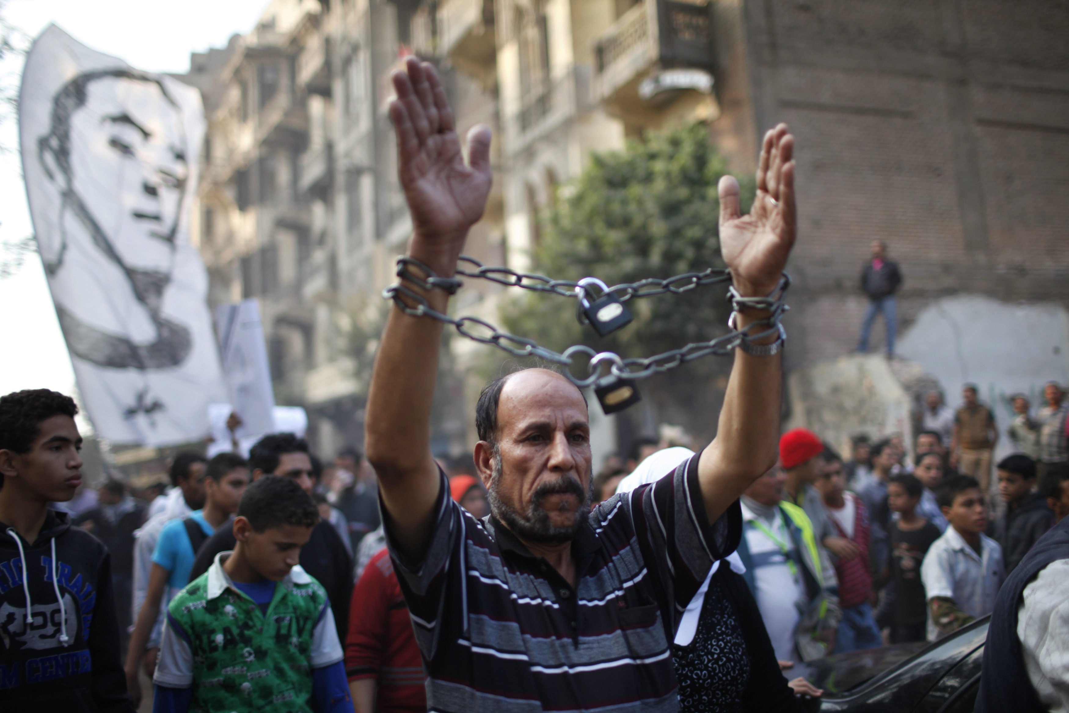 A mourner wearing chains attends the funeral of youth activist Gaber Salah, also known as Gika, at Tahrir in Cairo November 26, 2012. State news agency MENA reported that Salah, a member of the 6th of April youth movement, was wounded with birdshot in the head, neck, chest and arms and put on life support in intensive care, following last Monday's clashes between police and protesters on the anniversary of lethal street violence between activists and security. 