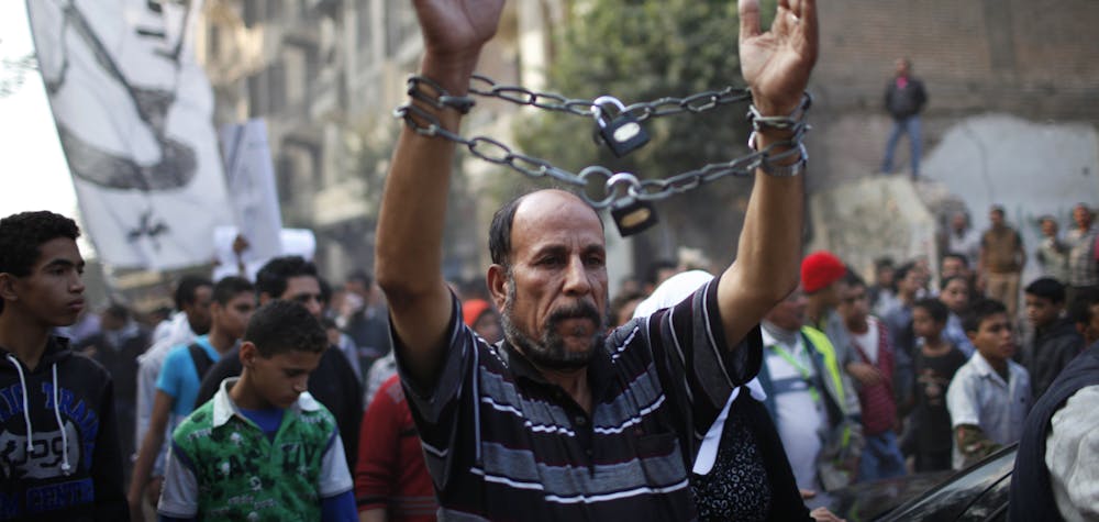 A mourner wearing chains attends the funeral of youth activist Gaber Salah, also known as Gika, at Tahrir in Cairo November 26, 2012. State news agency MENA reported that Salah, a member of the 6th of April youth movement, was wounded with birdshot in the head, neck, chest and arms and put on life support in intensive care, following last Monday's clashes between police and protesters on the anniversary of lethal street violence between activists and security. 