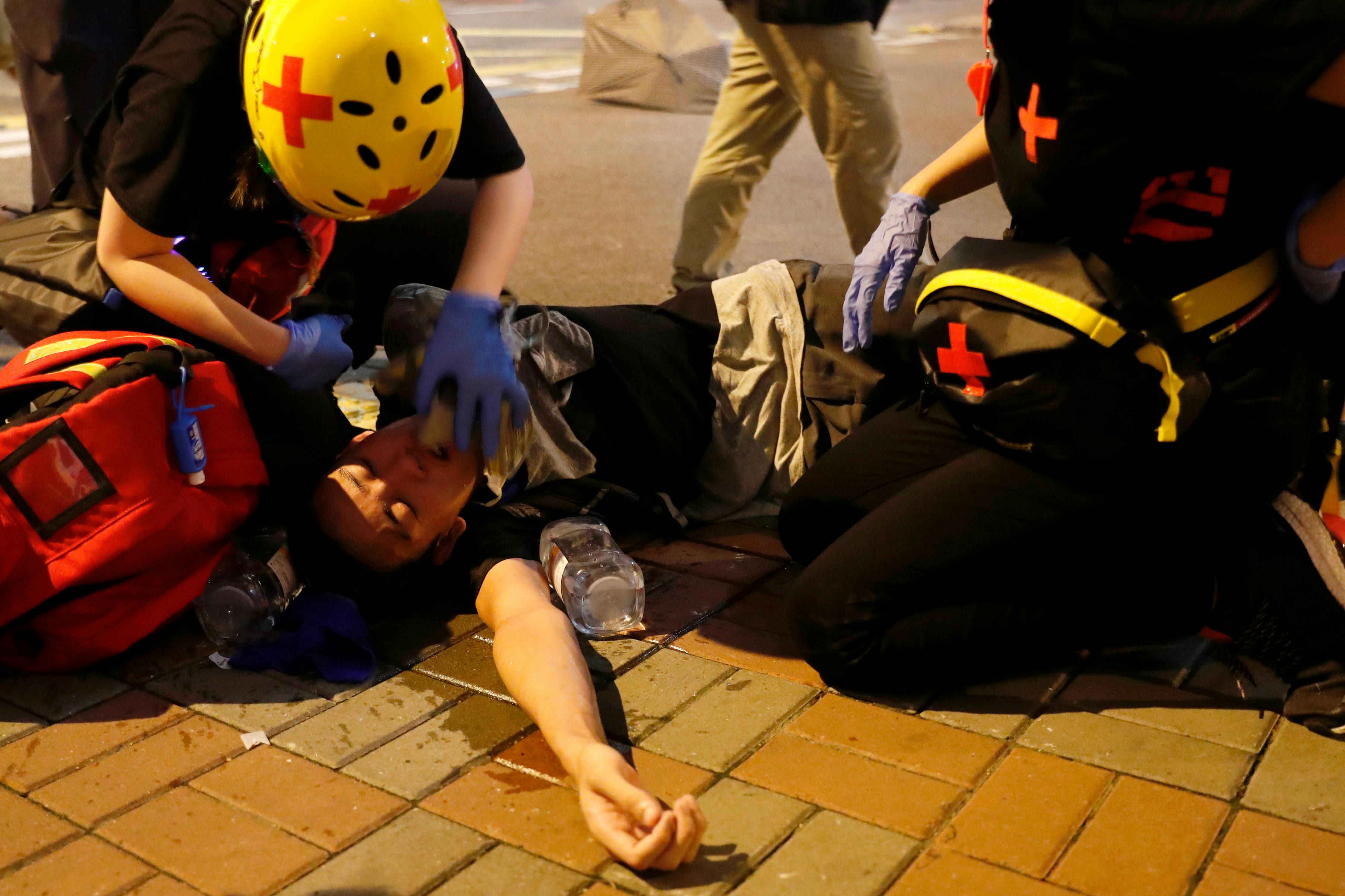 An anti-extradition bill demonstrator receives medical attention after riot police fire tear gas after a march to call for democratic reforms, in Hong Kong