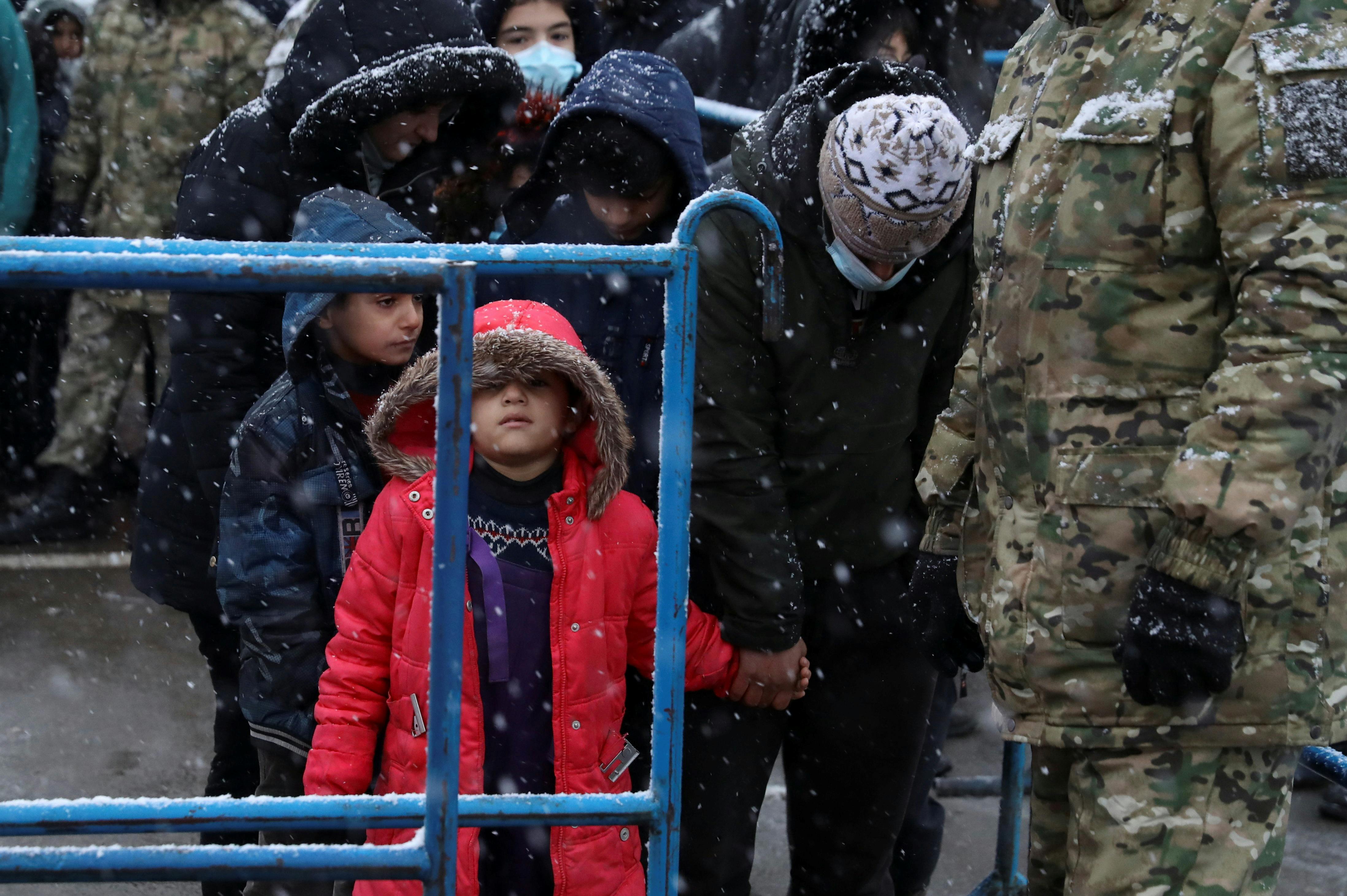 Des migrants se rassemblent dans un centre de transport et de logistique pendant une chute de neige, près de la frontière biélorusse-polonaise, dans la région de Grodno, en Biélorussie, le 23 novembre 2021. REUTERS/Kacper Pempel