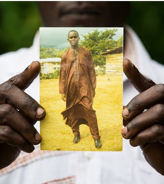 Le Frère de Fomusoh Ivo Feh tenant sa photo