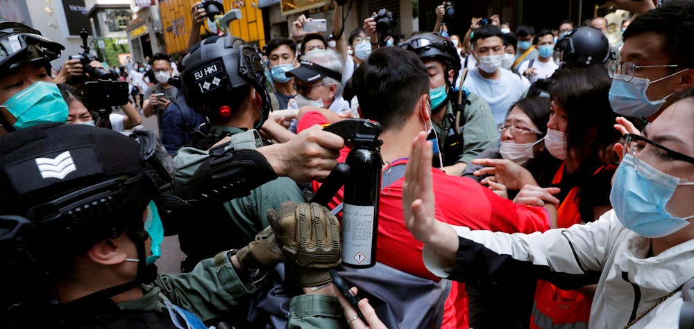 FILE PHOTO: Anti-government demonstrators scuffle with riot police during a lunch time protest as a second reading of a controversial national anthem law takes place in Hong Kong, China May 27, 2020. REUTERS/Tyrone Siu/File Photo