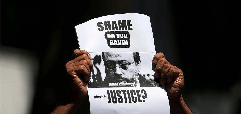 A member of Sri Lankan web journalist association holds a placard during a protest condemning the murder of slain journalist Jamal Khashoggi in front of the Saudi Embassy in Colombo