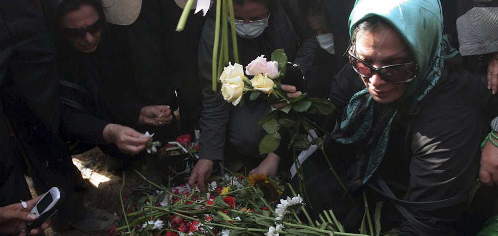 Iranians put flowers onto the grave of Neda Agha-Soltan as mourners gather at Tehran's Behesht-e Zahra cemetery July 30, 2009. Baton-wielding Iranian police fired tear gas on Thursday and arrested protesters mourning the young woman killed in post-election violence who has become a symbol for the opposition to Tehran's hardline leaders.  REUTERS/Reuters via Your View (IRAN CONFLICT POLITICS IMAGES OF THE DAY)