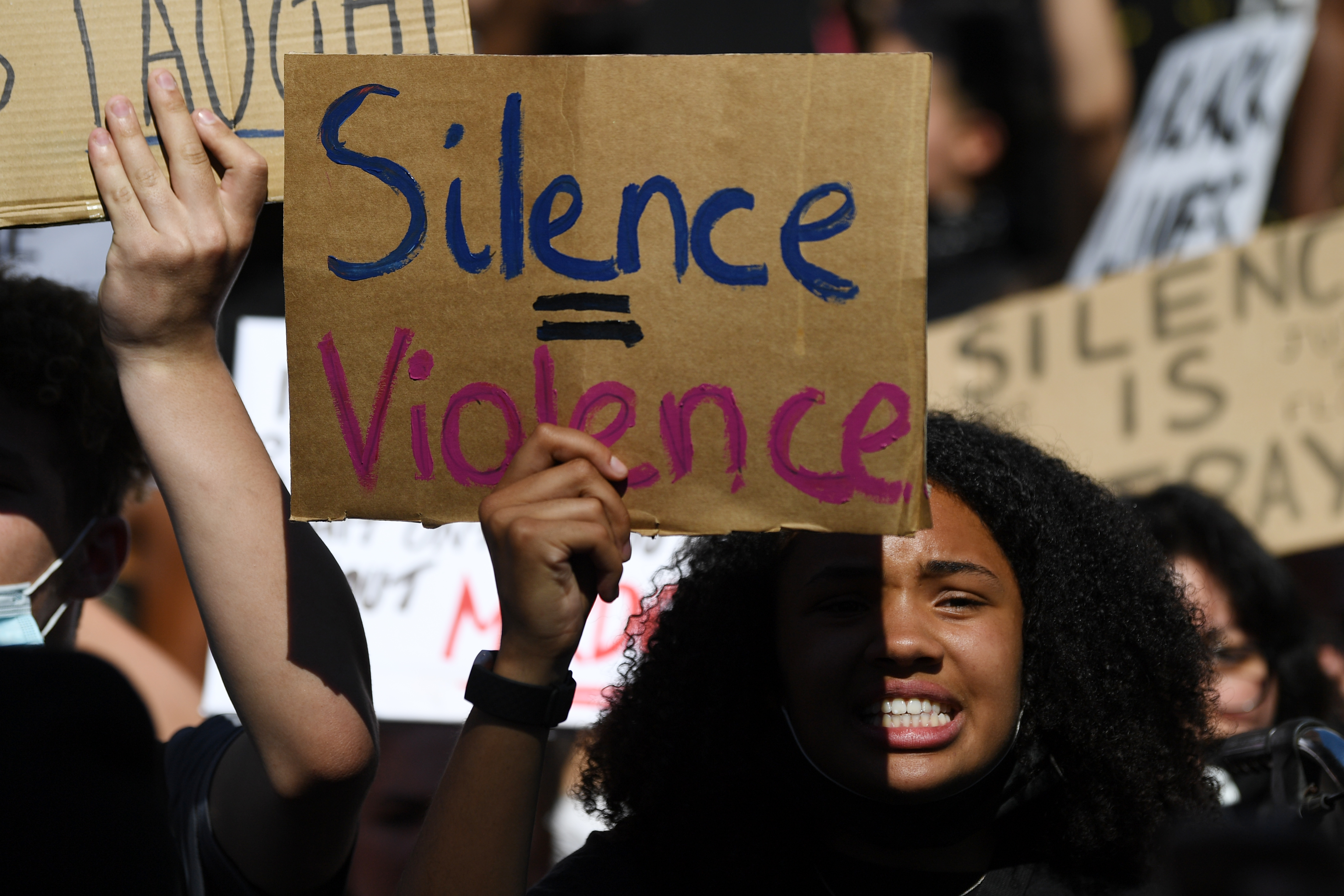 Demonstrators carry placards with slogans as they march near the US Embassy in London on May 31, 2020 to protest the death of George Floyd, an unarmed black man who died after a police officer knelt on his neck for nearly nine minutes during an arrest in Minneapolis, USA. - Hundreds gathered in central London and marched to teh US Embassy to protest the death of an unarmed black man in Minneapolis while in police custody that has sparked days of unrest in the US city and beyond. (Photo by DANIEL LEAL-OLIVAS / AFP)