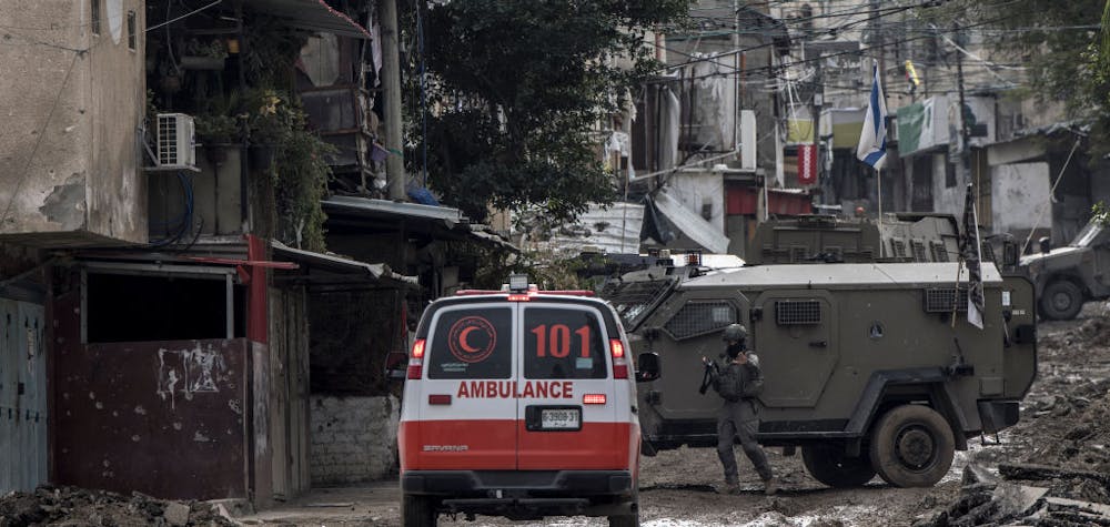 TOPSHOT - CORRECTION / An Israeli soldier gestures towards a Palestinian Red Crescent ambulance at the entrance of the Tulkarem refugee camp in Tulkarem, in the occupied West Bank, on January 17, 2024 during a military operation. (Photo by MARCO LONGARI / AFP) / "The erroneous mention appearing in the metadata of this photo by MARCO LONGARI has been modified in AFP systems in the following manner: [Red Crescent ambulance] instead of [Red Cross ambulance]. Please immediately remove the erroneous mention from all your online services and delete it from your servers. If you have been authorized by AFP to distribute it to third parties, please ensure that the same actions are carried out by them. Failure to promptly comply with these instructions will entail liability on your part for any continued or post notification usage. Therefore we thank you very much for all your attention and prompt action. We are sorry for the inconvenience this notification may cause and remain at your disposal for any further information you may require." (Photo by MARCO LONGARI/AFP via Getty Images) 