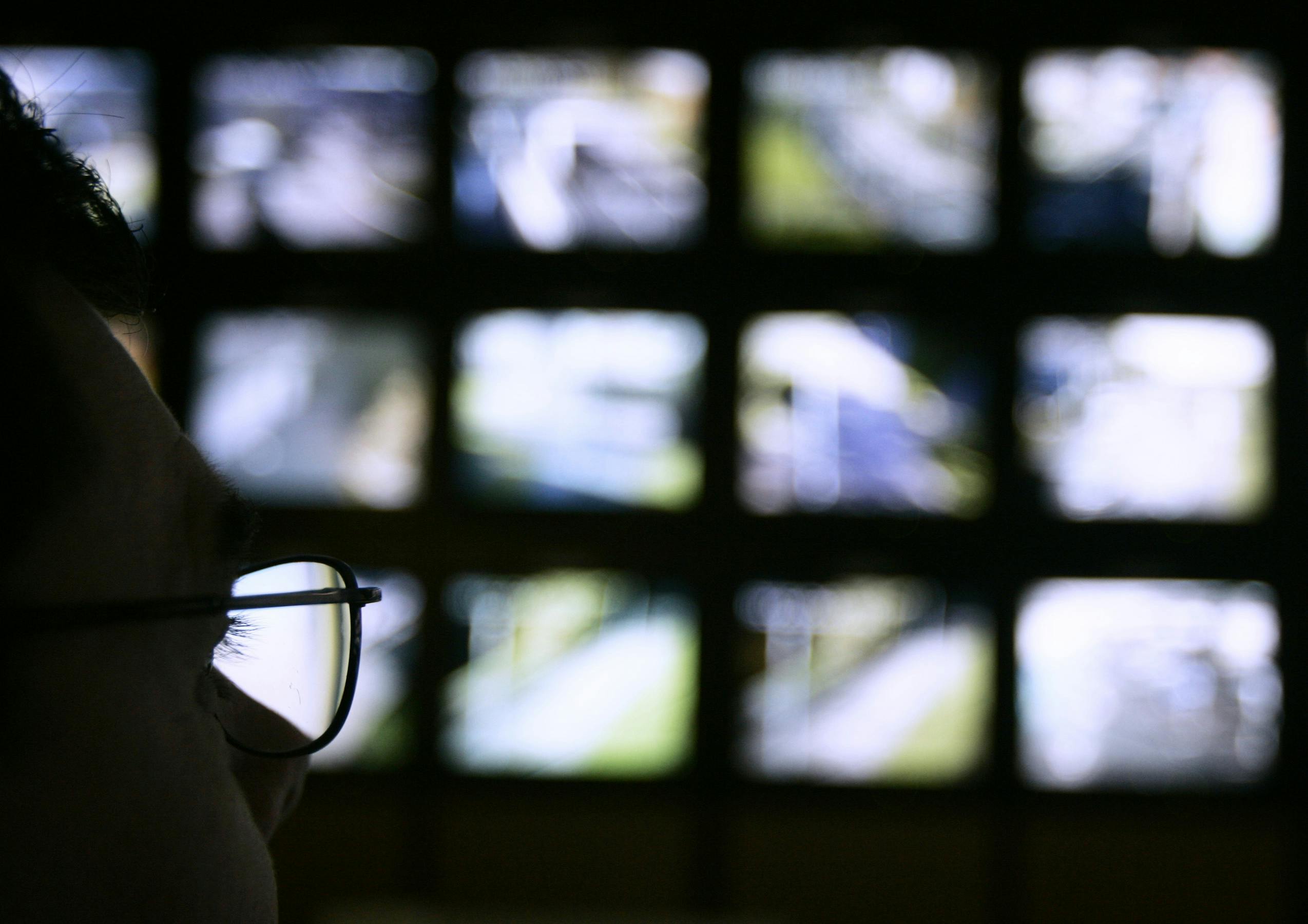 Surveillance monitoring expert watches a bank of screens showing images from Edinburgh City Council's network of CCTV cameras in Edinburgh