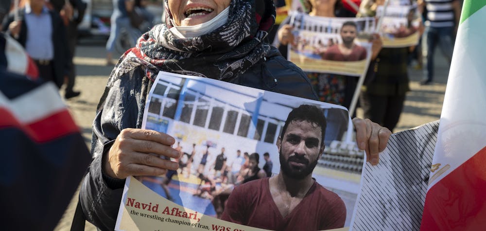A woman holds a portrait of Iranian wrestler Navid Afkari during a demonstration on the Dam Square in Amsterdam, the Netherlands, on September 13, 2020, against its execution in the southern Iranian city of Shiraz and against the Iranian government. Iran said it executed wrestler Navid Afkari, 27, on September 12, 2020 at a prison in the southern city of Shiraz over the murder of a public sector worker during anti-government protests in August 2018. Reports published abroad say Afkari was condemned on the basis of confessions 