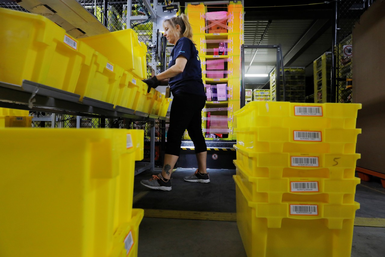 An Amazon employee works to stow items inside of shelves delivered by robots inside of an Amazon fulfillment center on Cyber Monday in Robbinsville, New Jersey, U.S., December 2, 2019.  REUTERS/Lucas Jackson