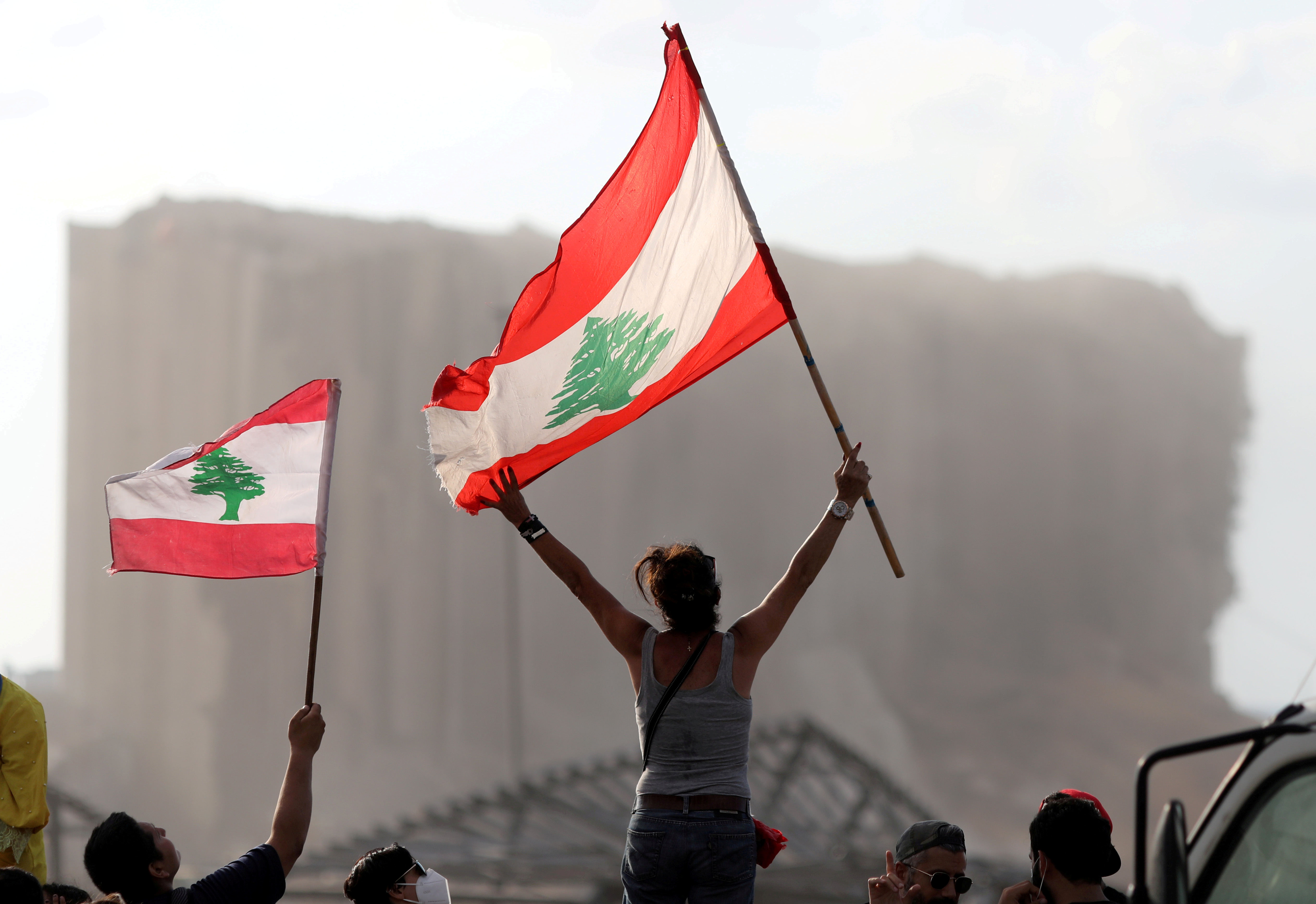 Demonstrators wave Lebanese flags during protests near the site of a blast at Beirut's port area, Lebanon August 11, 2020. 