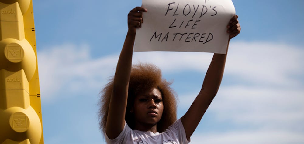 	MINNEAPOLIS, MN - MAY 26: A woman holds a sign stating "George Floyd's Life Mattered" during a protest outside the Cup Foods on May 26, 2020 in Minneapolis, Minnesota. Four Minneapolis police officers have been fired after a video taken by a bystander was posted on social media showing Floyd's neck being pinned to the ground by an officer as he repeatedly said, "I canâ€™t breathe". Floyd was later pronounced dead while in police custody after being transported to Hennepin County Medical Center.