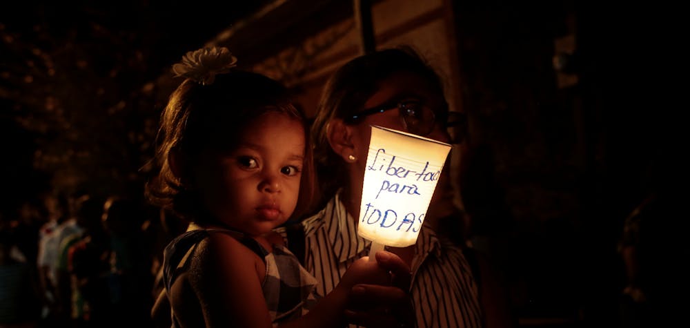 A faithful and her daughter hold a candle reading " Freedom for all political prisoners", during the procession of "El Silencio" in Masaya, Nicaragua April 18, 2019. REUTERS/Oswaldo Rivas