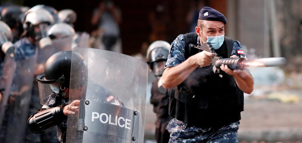 A member of Lebanese riot police fires a weapon during anti-government protests that have been ignited by a massive explosion in Beirut, Lebanon August 10, 2020. 