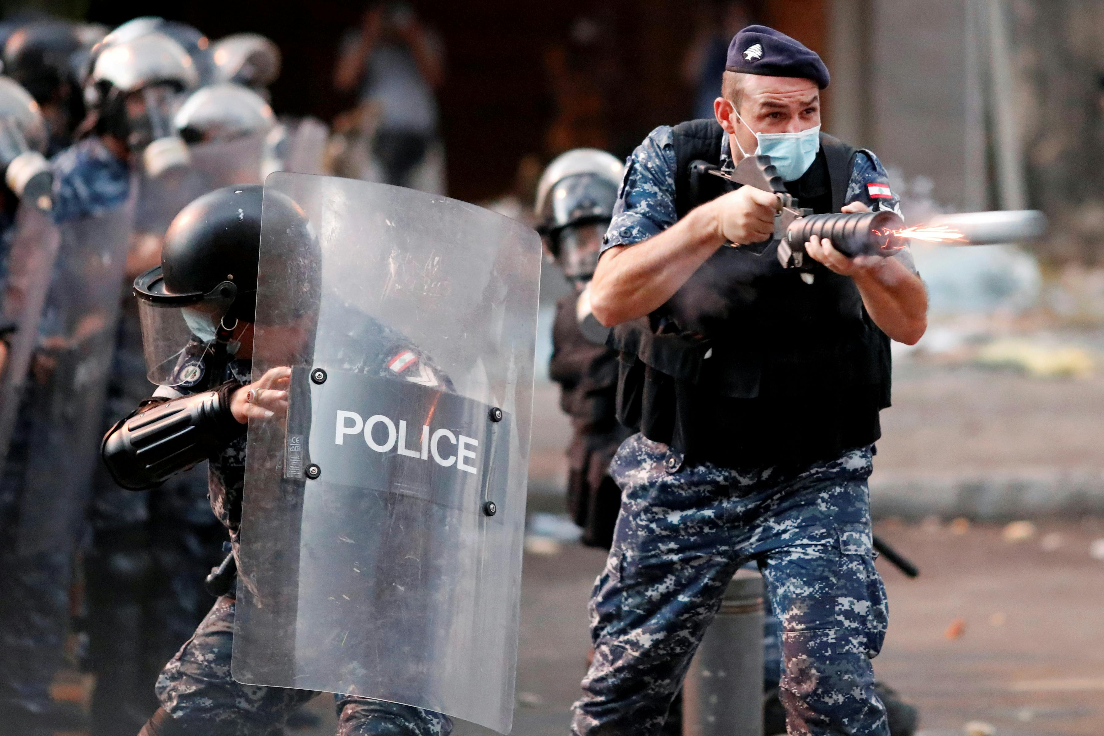 A member of Lebanese riot police fires a weapon during anti-government protests that have been ignited by a massive explosion in Beirut, Lebanon August 10, 2020. 