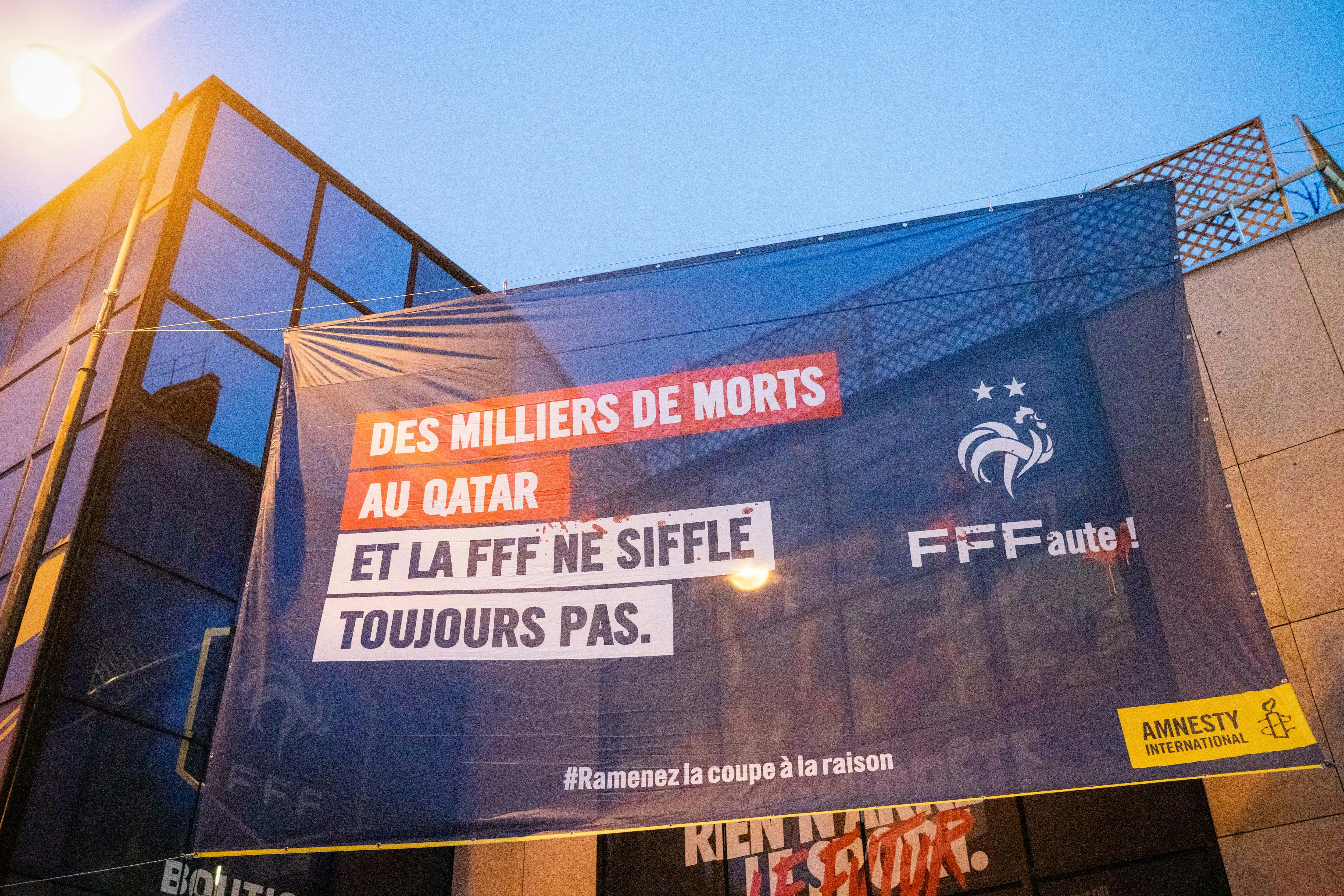 Photo prise le 15 décembre 2021, devant le siège de la Fédération Française de Football pour leur rappeler leurs responsabilités vis-à-vis des violations de droits humains des travailleurs migrants au Qatar, dans le cadre de la coupe du monde 2022. Crédit : Benjamin Girette