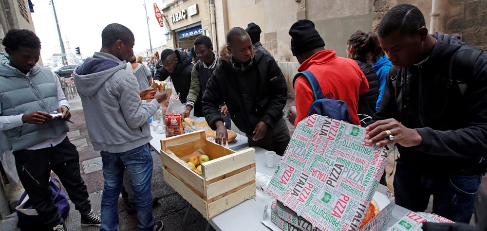 
Des Volontaires distribuent de la nourriture aux migrants alors qu'ils occupent l'église Saint-Ferréol pour protester contre les conditions de vie des mineurs migrants non accompagnés à Marseille