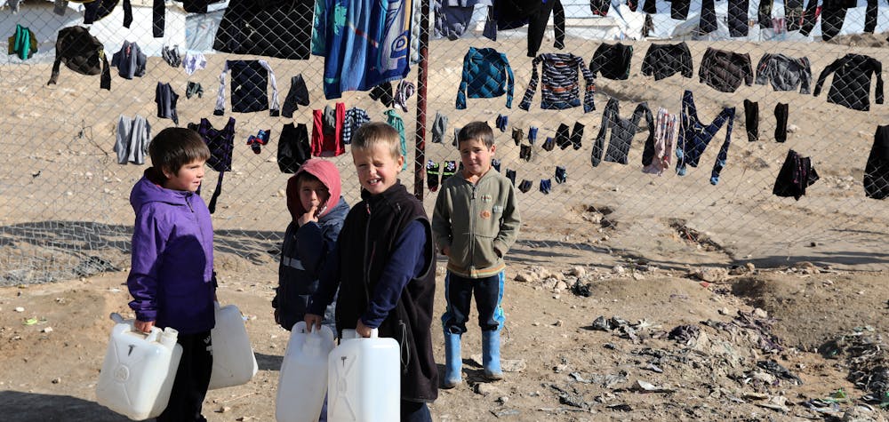Enfant dans le camp Al Hol en Syrie EI rapatriement - Des enfants s'accrochent à des récipients d'eau dans le camp d'Al-Hol, en Syrie, le 8 janvier 2020  Goran Tomasevic/REUTERS