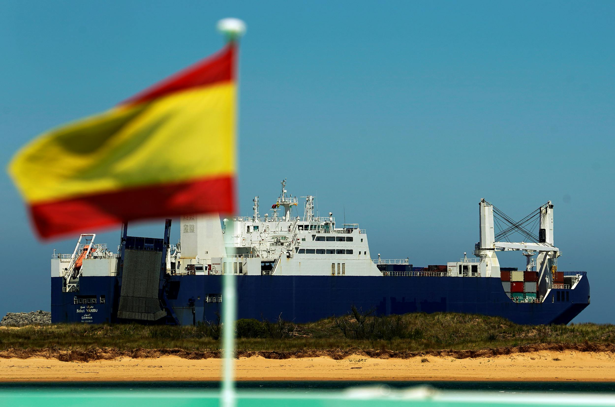 Saudi cargo ship Bahri-Yanbu passes a Spanish flag while departing the port of Santander, Spain May 13, 2019, after a human rights group sought to block the loading of a weapons cargo in Le Havre on humanitarian grounds, arguing the arms could be used against civilians in Yemen. 