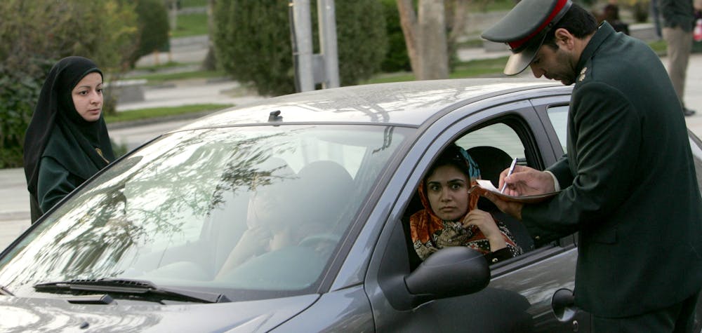 Iran - Théréan 22/04/2007 : des policiers iraniens arrêtent une voiture lors d'une opération de répression visant à faire respecter le code vestimentaire islamique dans le nord de Téhéran. L'Iran a émis plus d'un millier d'avertissements et arrêté des dizaines de personnes dans le cadre d'une nouvelle campagne visant à contraindre les femmes dont la tenue vestimentaire est jugée inappropriée à se conformer aux règles vestimentaires islamiques. 