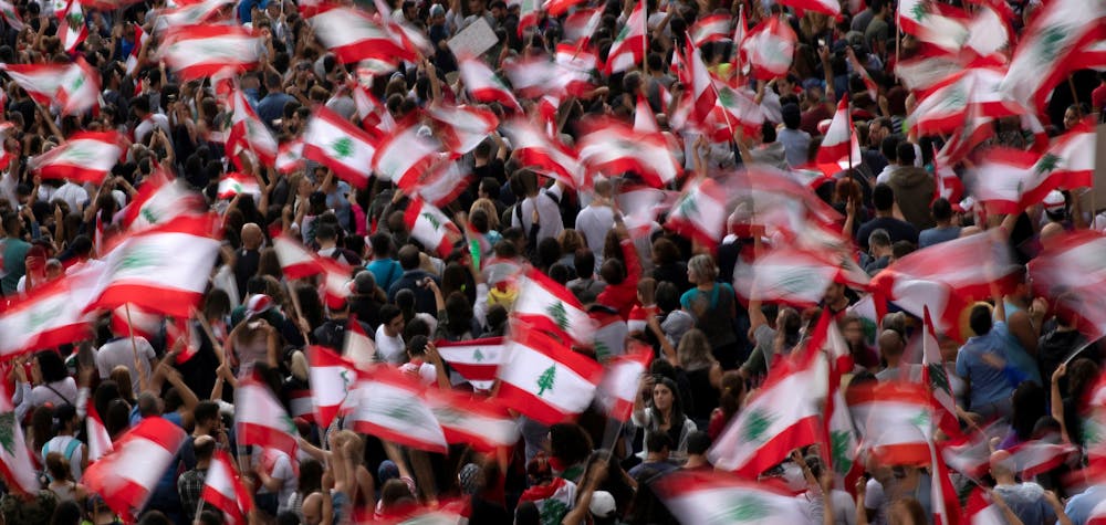 Demonstrators wave Lebanese national flags during ongoing anti-government protests at a highway in Jal el-Dib, Lebanon, October 23, 2019. 