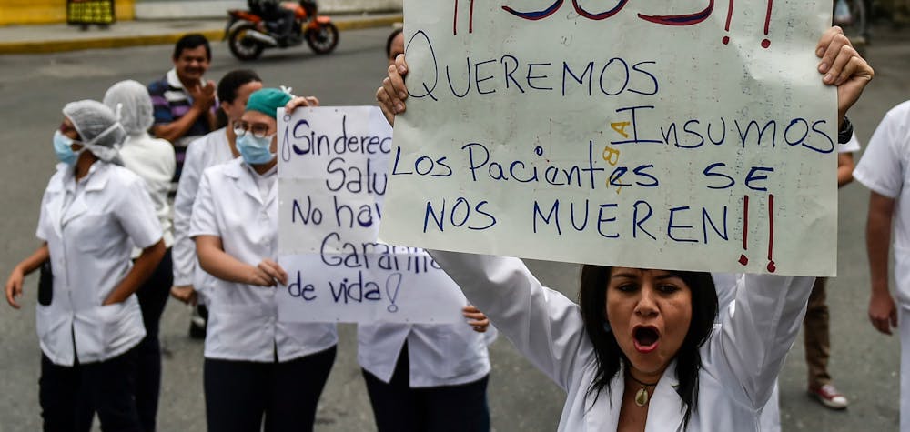  	Health workers and patients protest for the lack of medicines, medical supplies and poor conditions in hospitals, in Caracas on April 17, 2018. - Doctors and nurses protest against the health crisis in Venezuela, currently in the midst of a deep economic and political crisis and where health authorities have reported a rise in vaccine-preventable diseases. (Photo by Luis ROBAYO / AFP) (Photo credit should read LUIS ROBAYO/AFP via Getty Images) 