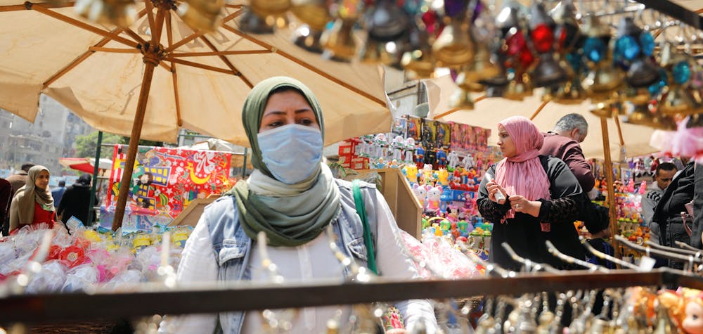 Une femme portant un masque protecteur, au milieu des inquiétudes suscitées par la maladie du coronavirus (COVID-19) achète des lanternes traditionnelles du Ramadan, appelées "Fanous", qui sont exposées à la vente sur un étal, avant le mois sacré musulman du Ramadan au Caire, en Égypte, 12 avril 2020. 