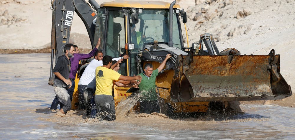 Activists try to block an Israeli machinery in the Palestinian Bedouin village of Khan al-Ahmar that Israel plans to demolish, in the occupied West Bank