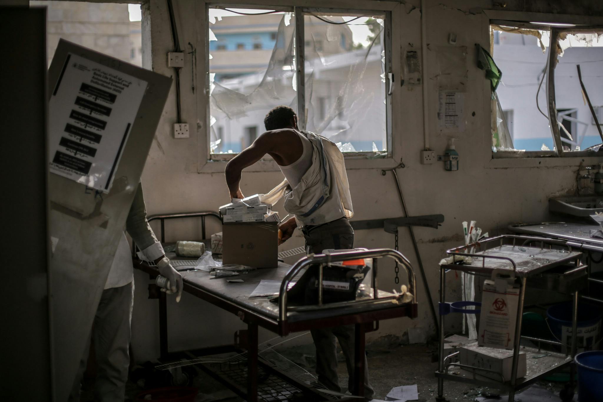 Des employés tentent de sauver du matériel dans l'hôpital de MSF bombardé à Abs, Yemen