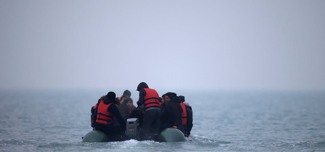 Un groupe de plus de 40 personnes exilées sur un canot pneumatique quitte la côte du nord de la France pour traverser la Manche, près de Wimereux, le 24 novembre 2021