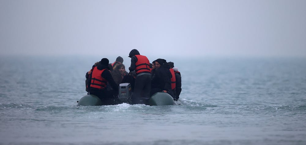 Un groupe de plus de 40 personnes exilées sur un canot pneumatique quitte la côte du nord de la France pour traverser la Manche, près de Wimereux, le 24 novembre 2021