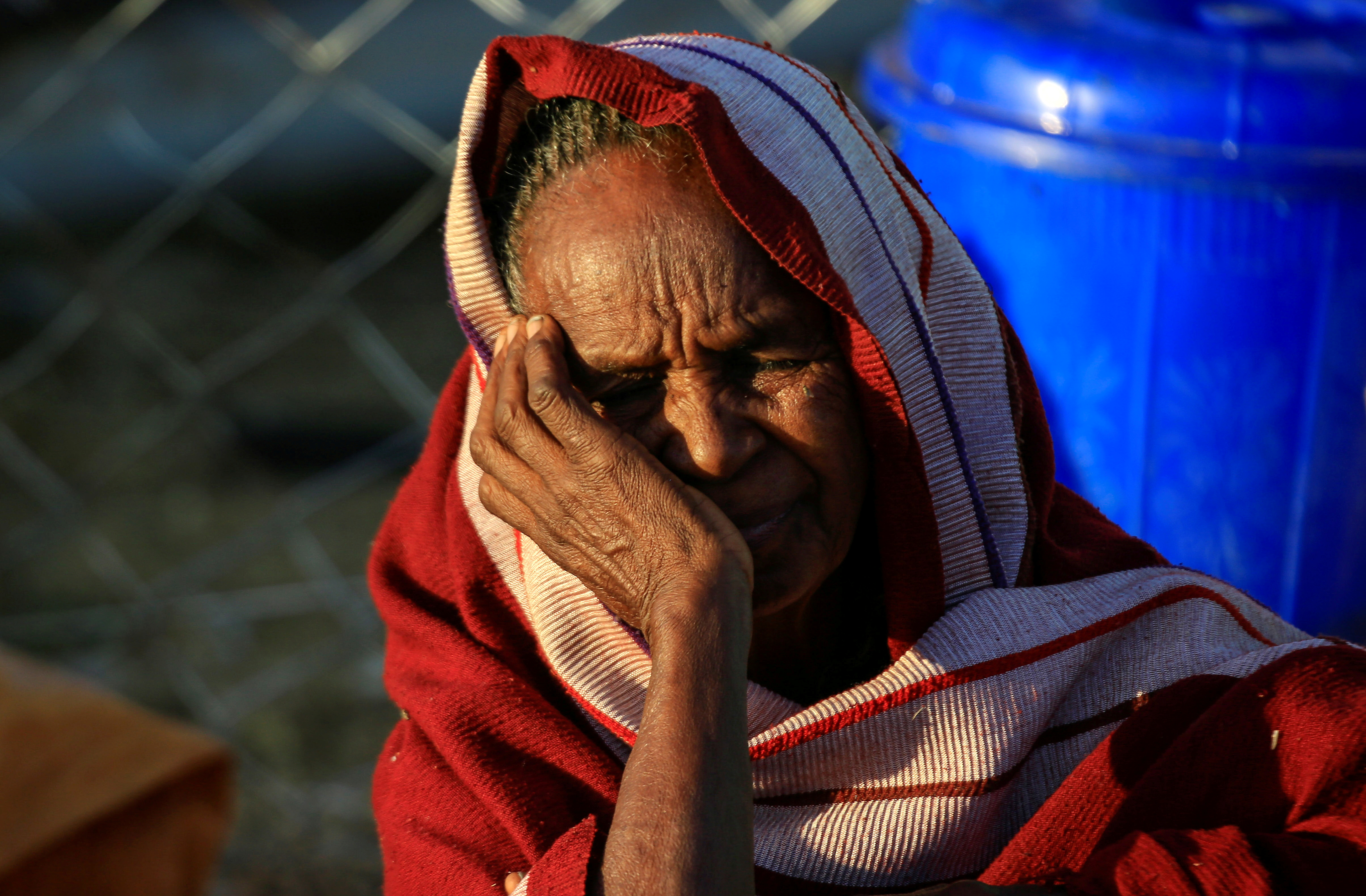 An Ethiopian woman, who fled the ongoing fighting in Tigray region, is seen at dawn within Hamdayet village on the Sudan-Ethiopia border, in the eastern Kassala state, Sudan December 16, 2020