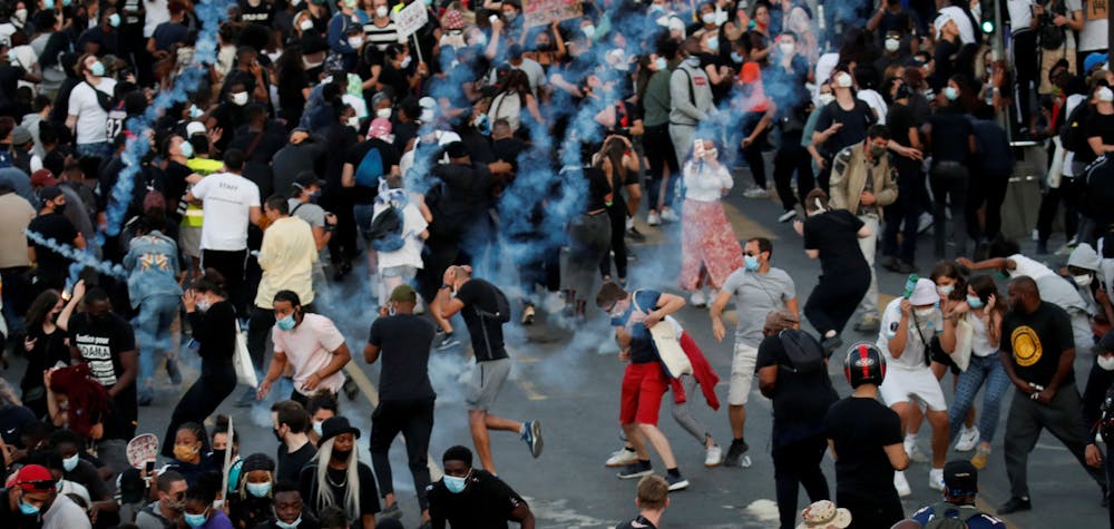 People run from tear gas as they attend a banned demonstration planned in memory of Adama Traore, a 24-year-old black Frenchman who died in a 2016 police operation which some have likened to the death of George Floyd in the United States, in front of courthouse in Paris, France June 2, 2020. REUTERS/Gonzalo Fuentes