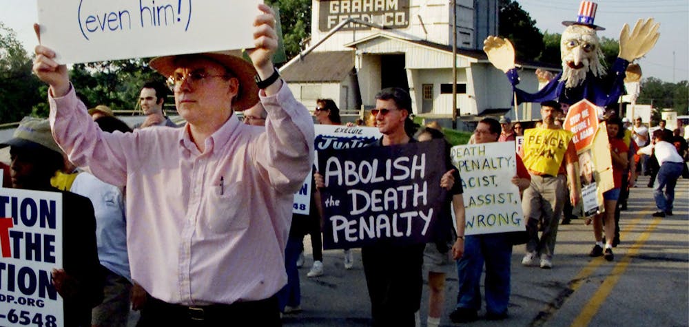 Anti-death penalty demonstrators march past the grain silo of a Terre Haute, Indiana, farm June 10, 2001 as they make their way to the Federal Penitentiary to protest the execution of Oklahoma City bomber Timothy McVeigh. McVeigh is expected to be put to death by lethal injection June 11 in the first federal execution since 1963.