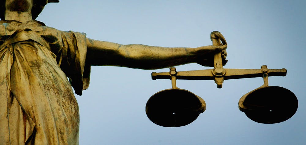 A statue holding the scales of justice is seen on top of the Old Bailey in London, December 12, 2003. REUTERS/Stephen Hird 