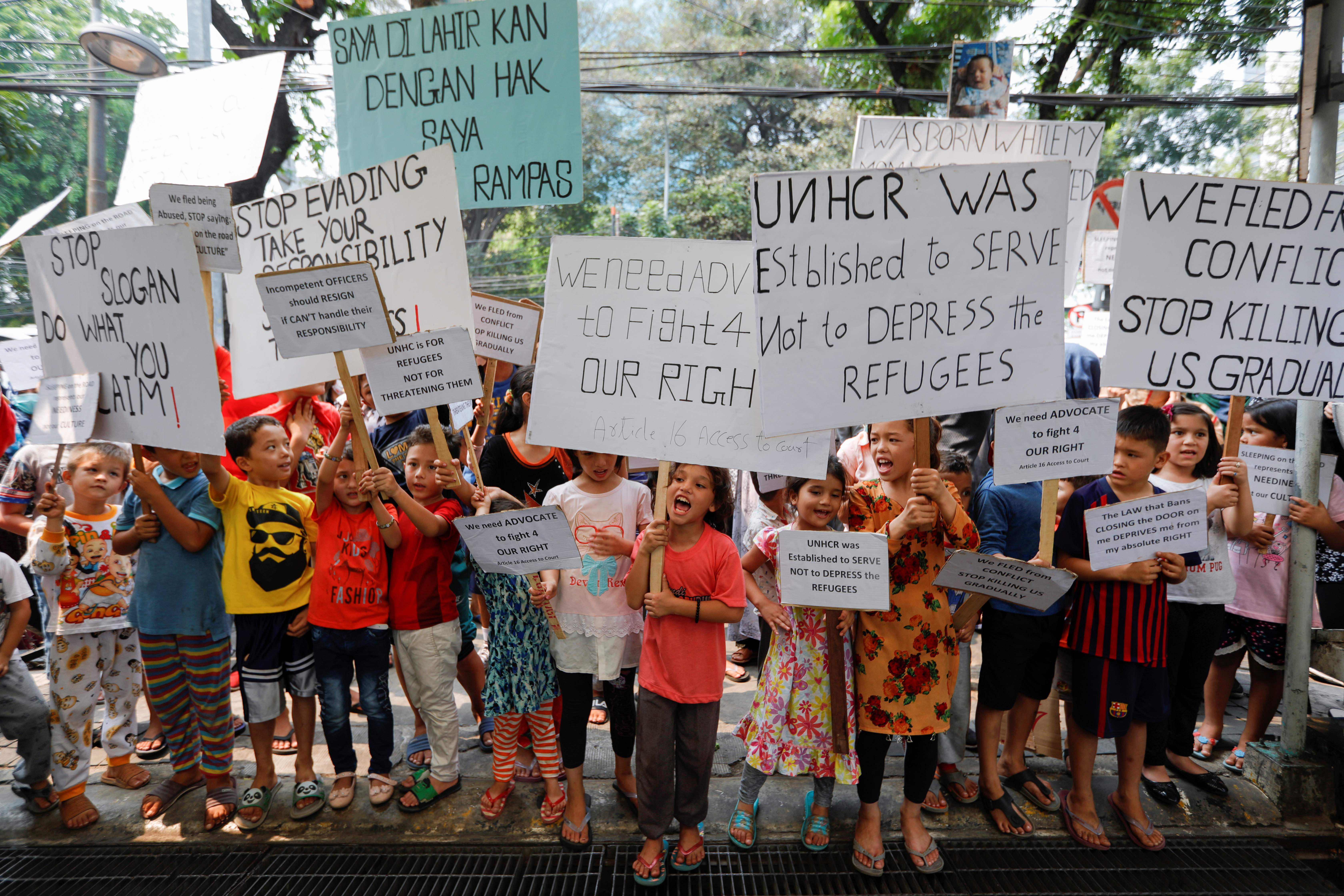 Displaced children hold placards as they take part on a protest outside UN Refugee Agency UNHCR's office in Jakarta, Indonesia, Octoer 10, 2019. REUTERS/Willy Kurniawan