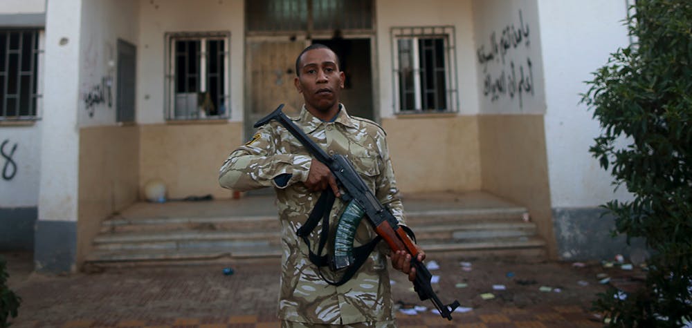 Un garde de sécurité armé se tient devant un poste de police à Benghazi, le 4 décembre 2014