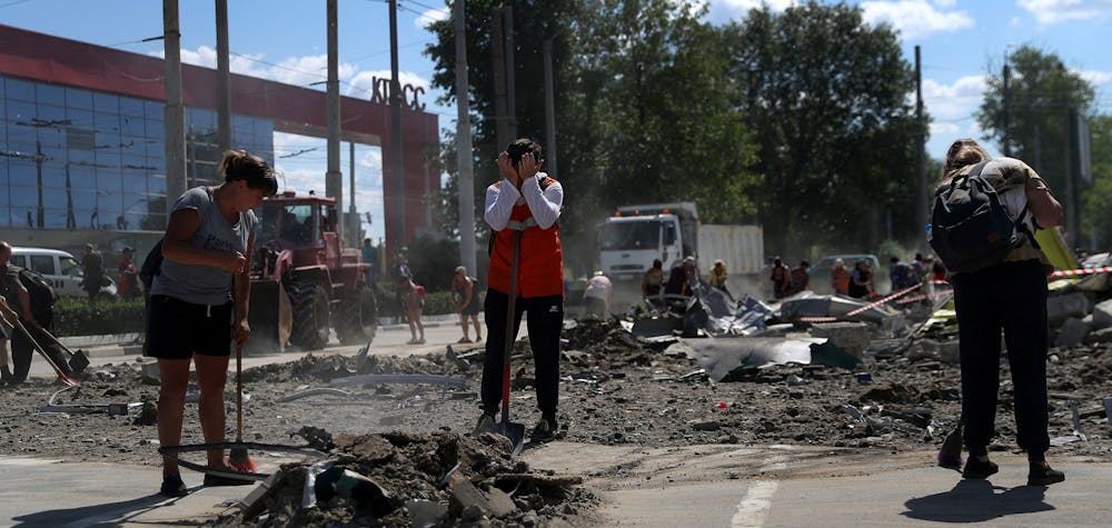 Des habitants enlèvent les débris d'un supermarché dans un centre commercial endommagé par une frappe de missile russe, alors que l'attaque de la Russie contre l'Ukraine se poursuit, à Kharkiv, en Ukraine, le 8 juin 2022. 